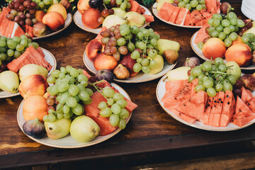 Plates with fruits and berries on the holiday table.