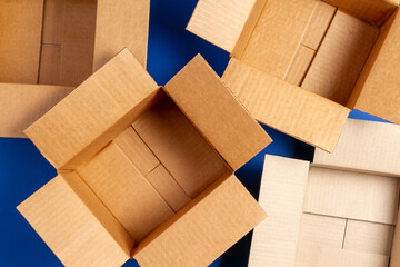 Empty open cardboard boxes on blue background. Top view
