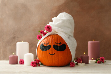 Candles and pumpkin with eye patches on brown background