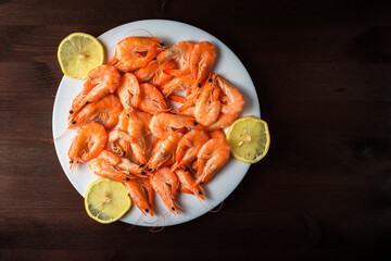 shrimp on a plate with lemons on a wooden table