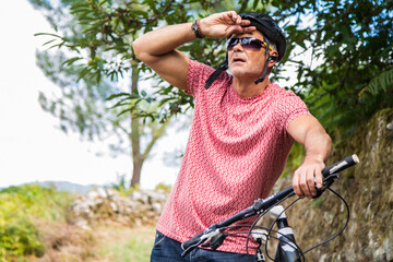 fatigued cyclist on her bike stopped on the road