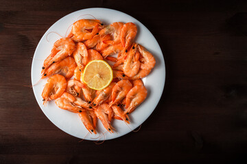 shrimp on a plate with lemons on a wooden table