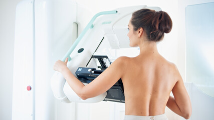 Healthy young woman doing cancer prophylactic mammography scan at hospital. - obrazy, fototapety, plakaty