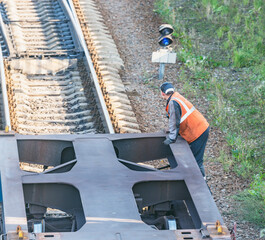 Railway worker stands on the freight railway carriage.