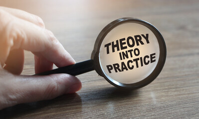 Hand Showing Theory into Practice Words Through Magnifying Glass. Business training concept
