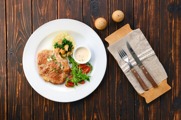 Fried pork meat, mashed potato, mushrooms and tomato