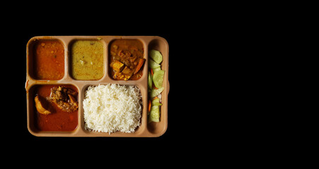 indian chicken thali with rice dal chicken salad vegetable curry on a plastic segmented plate in...