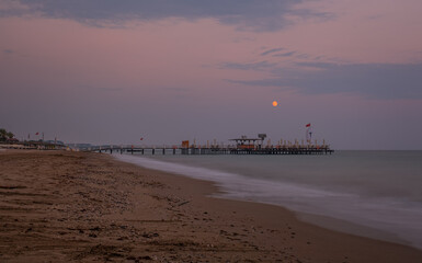 Massive concrete pier leading to horizon surrounded by Mediterranean sea. Long exposure shot made...