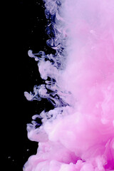 Beautiful pink abstraction on a dark background made of paint in water.