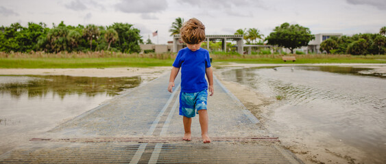 Boy playing on the beach at siesta Key florida with the snd and birds 