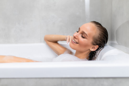 Young beautiful woman relaxing in foam in a bathtub