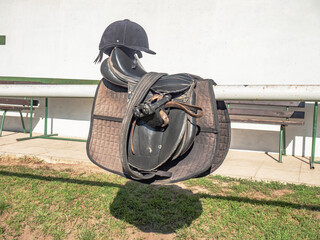 Comfortable saddles laying on fence in warm sunlight.