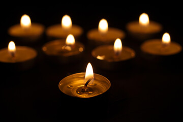 Burning candles. Many Christmas candles are burning in the dark. focus in foreground, candles out of focus.