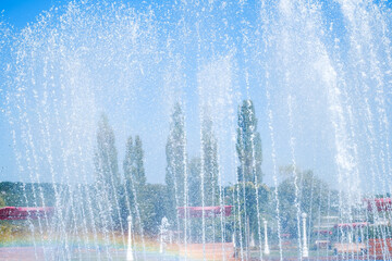 artesian fountain on blue sky with rainbow