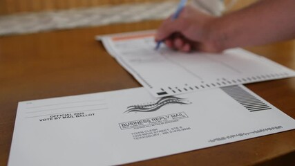Filling out Vote By Mail election ballot at home to send in.