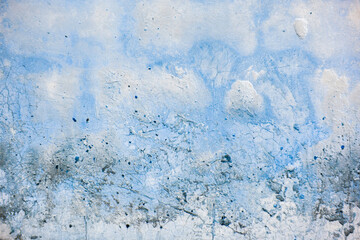Rough dirty light blue wall with cracks, streaks and spots as a abstract background