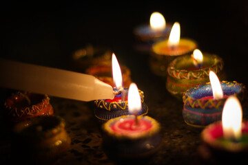earthen diya lamp lighting with candles on the occasion of diwali and sandhi pujo