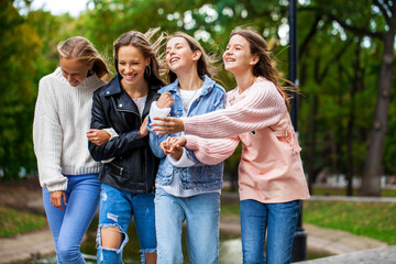 Four teenagers girls walking in autumn park