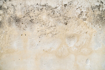 Dirty beige light concrete wall with dents and holes and spots as background