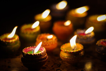 earthen diya lamp lighting with candles on the occasion of diwali and sandhi pujo