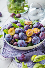 close-up view of bowl with fresh plums on table