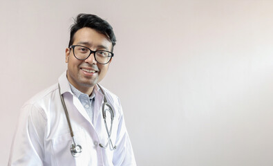 male indian doctor in white coat and stethoscope with space for text in white background