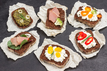 Different kinds of colorful sandwiches on black