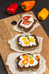 Appetizing bruschetta with various toppings on paper on board.