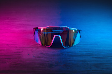 Sport glasses on the table close up in neon lights background.
