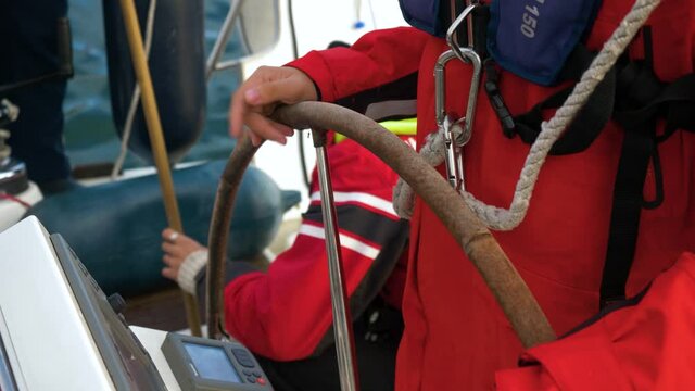 Close Up Shot of the Helmsman Steering a Sailboat in Calm Sea