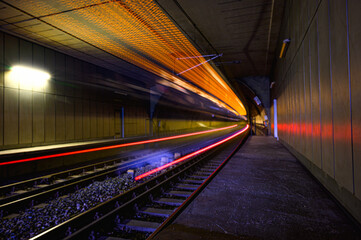 Train with speeding lights driving through a tunnel on railways