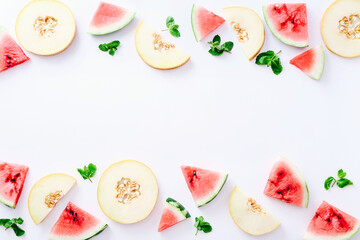 Frame of sliced watermelon and melon with mint leaves on white background. Top view