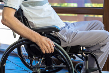 Obraz premium Close up of a disabled man in a wheelchair near the window