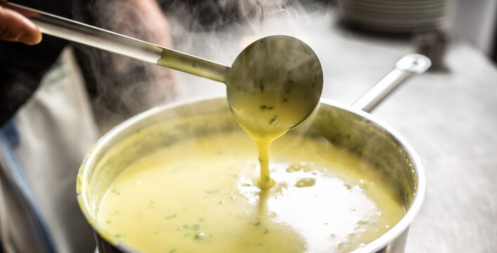 Creamy vegetable mixed soup steaming as ladle stirs it in a pot