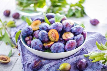 close-up view of bowl with organic plums on table
