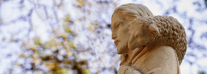 Ancient statue of Jesus Christ Good Shepherd.  Close up. Faith, Christianity, God concept. Horizontal image.