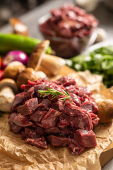 Sliced deer meat prepared for stew of game forest mushrooms herbs and vegetables