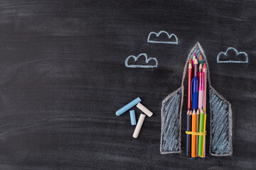 Top above overhead view photo of drawn spaceship chalk and clouds isolated on blackboard background...