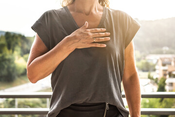 A woman with her hand on her heart. WHO recommended greeting