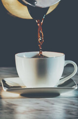 pouring coffee into a white cup