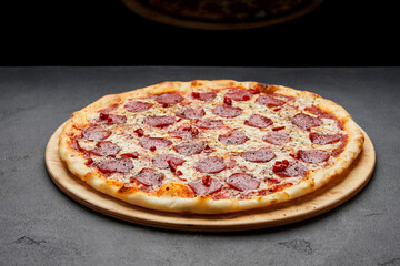 Delicious Italian Pizza pepperoni with mozzarella cheese and salami on dark background