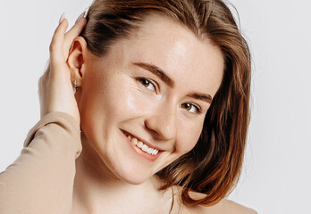 Naklejka premium Beautiful young girl smiling and posing looking at the camera on a white isolated background. Positive brunette woman. Kind look. Beauty face.