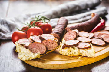 Sandwiches with homemade smoked sausage located on a board - food for consolation - tasty and healthy