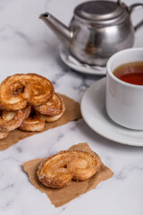 tea with milk and Palmiers cookies on marble