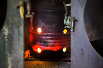 Red-hot iron barrel in a dark production room