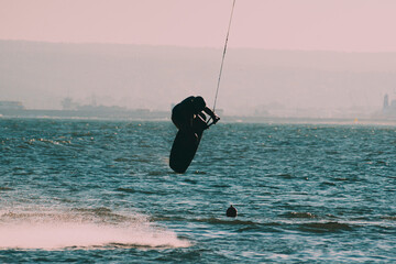 WAKEBOARDING AT THE SEA JUMPING HIGH DOING A BACKFLIP.