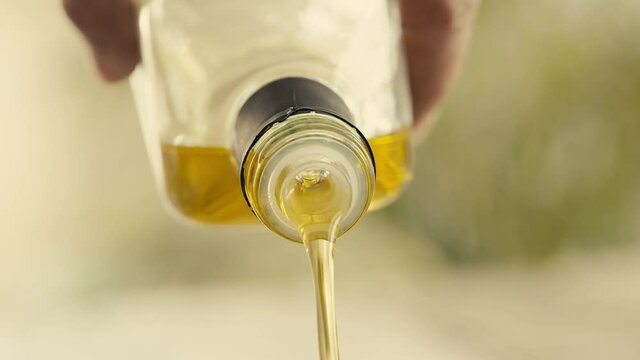Pouring olive oil from glass bottle