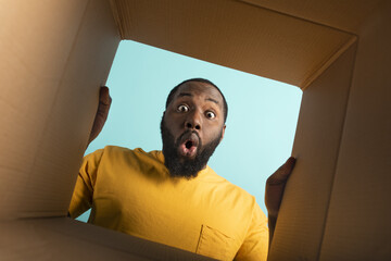 Happy boy receives a package from online shop order. happy and surprised expression. Blue...