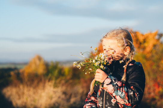 cute blond girl with wild flowers bouquet