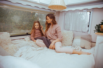 Happy family - mother and little daughter relaxing hugging and having fun in countryside inside...